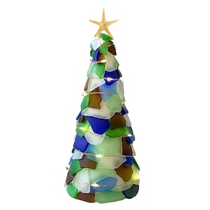 May include: A decorative Christmas tree made of sea glass in shades of green, blue, brown, and white. The tree is topped with a starfish and wrapped with copper wire lights. The tree is a unique coastal-themed decoration.