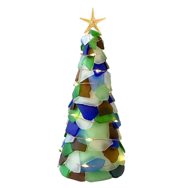 May include: A decorative Christmas tree made of sea glass in shades of green, blue, brown, and white. The tree is topped with a starfish and wrapped with copper wire lights. The tree is a unique coastal-themed decoration.