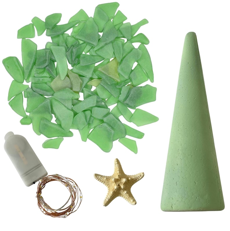 May include: A collection of craft supplies including green sea glass pieces, a light green cone, a gold starfish, and a string of fairy lights with a battery pack. The items are arranged on a white background.