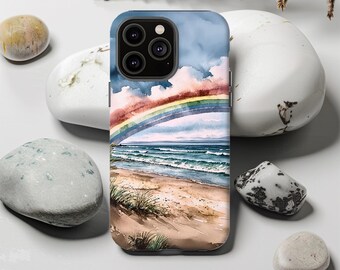 May include: A phone case featuring a watercolor painting of a beach scene with a rainbow arching over the ocean. The design includes a sandy beach, ocean waves, and a cloudy sky. The case is a protective accessory for a smartphone.