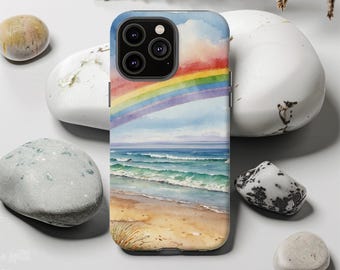 May include: A phone case featuring a watercolor painting of a beach scene with a rainbow. The design includes a sandy beach, ocean waves, and a colorful rainbow against a blue sky. The case is designed to fit a smartphone.