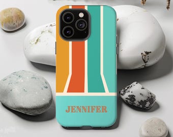 May include: A teal phone case with a retro design featuring vertical stripes in orange, teal, and yellow. The name "JENNIFER" is printed in orange at the bottom. The case is surrounded by decorative stones and dried plants.