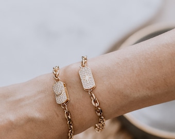Può includere: Due braccialetti a catena dorati con un ciondolo a forma di stella e mezzaluna. I ciondoli sono incrostati di strass trasparenti.