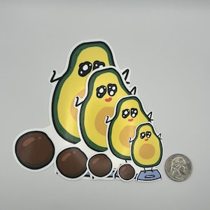 Puede incluir: Un conjunto de pegatinas de aguacate de varios tamaños, cada una con una cara sonriente y un hueso marrón. Los aguacates son amarillos y verdes, con un borde blanco. Se incluye una moneda como referencia de tamaño.