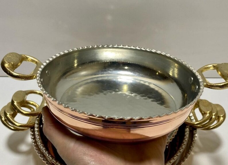 K&ouml;nnte beinhalten: Set aus vier Servier Schalen aus Kupfer und Messing mit geh&auml;mmerten Metalloberfl&auml;chen und dekorativen Perlenr&auml;ndern. Die Schalen haben eine gl&auml;nzende Oberfl&auml;che und sind &uuml;bereinander gestapelt.
