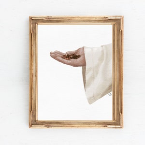 Puede incluir: Una pintura de una mano sosteniendo un montón de granos de café. La mano lleva una túnica blanca. La pintura está enmarcada en un marco dorado.