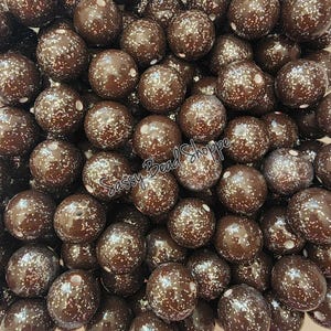 May include: A close-up image of a large quantity of brown and silver glitter round beads. The beads are all the same size and are arranged in a random pattern. The beads are perfect for making jewelry, crafts, and other projects.