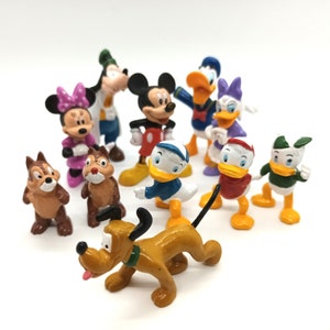 Pode incluir: Uma cole&ccedil;&atilde;o de figuras de personagens da Disney, incluindo Mickey Mouse, Minnie Mouse, Pato Donald, Margarida, Pateta e Pluto. As figuras s&atilde;o coloridas e feitas de pl&aacute;stico, com detalhes precisos. Os personagens est&atilde;o dispostos em uma superf&iacute;cie branca.