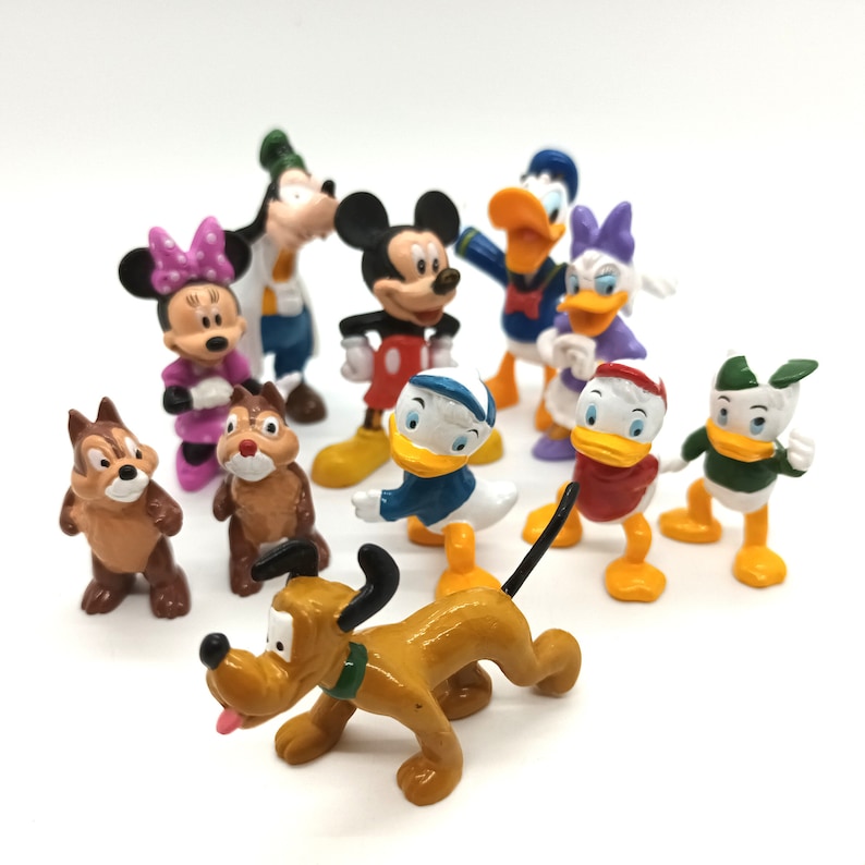 Pode incluir: Uma cole&ccedil;&atilde;o de figuras de personagens da Disney, incluindo Mickey Mouse, Minnie Mouse, Pato Donald, Margarida, Pateta e Pluto. As figuras s&atilde;o coloridas e feitas de pl&aacute;stico, com detalhes precisos. Os personagens est&atilde;o dispostos em uma superf&iacute;cie branca.