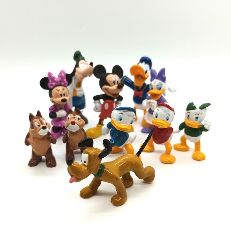 Pode incluir: Uma cole&ccedil;&atilde;o de figuras coloridas de personagens da Disney, incluindo Mickey Mouse, Minnie Mouse, Pato Donald, Margarida, Pateta, Pluto e Tico e Teco. As figuras s&atilde;o feitas de pl&aacute;stico e est&atilde;o sobre um fundo branco.