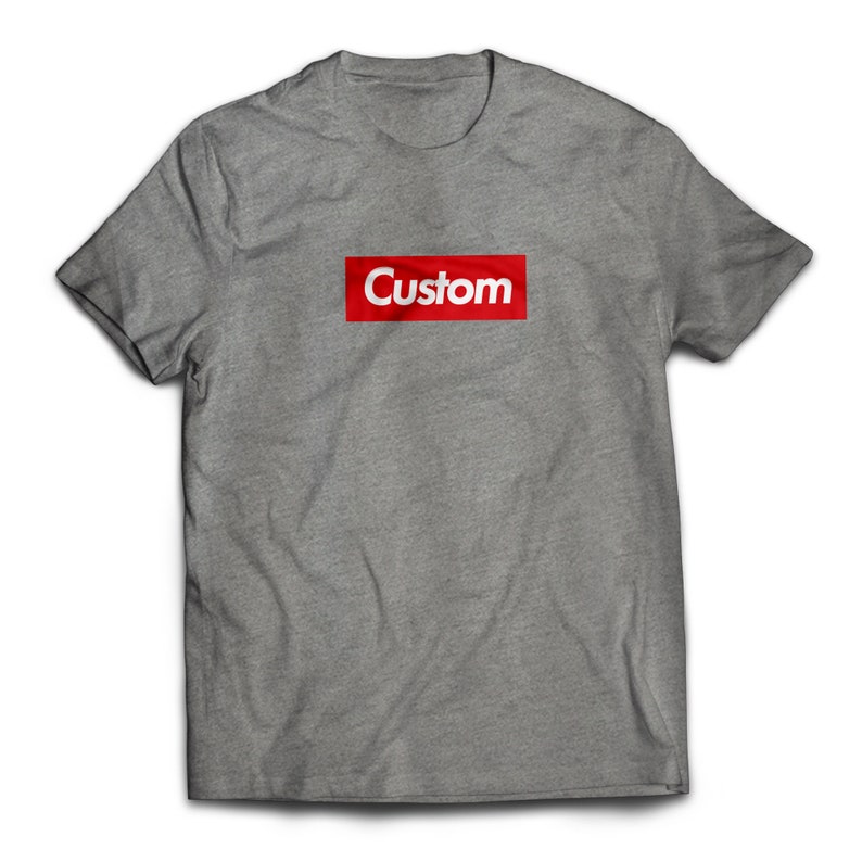 May include: A gray t-shirt with a red box that says "Custom" in white letters.