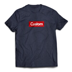 May include: A navy blue t-shirt with a red box and the word "Custom" in white letters.