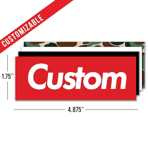 May include: Red rectangular sticker with the word "Custom" in white letters. The sticker is 4.875 inches wide and 1.75 inches tall.