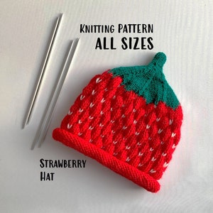 Puede incluir: Patrón de tejido para un gorro de fresa en todas las tallas. El gorro es rojo con detalles blancos y una parte superior verde. El patrón incluye agujas de tejer.