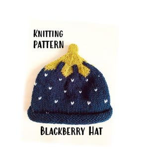 May include: Knitting pattern for a blackberry hat. The hat is blue with white hearts and a yellow top.
