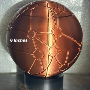 May include: A 6-inch copper-coloured sphere with a geometric pattern. The sphere is on a black base.