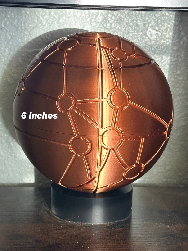 May include: A 6-inch copper-coloured sphere with a geometric pattern. The sphere is on a black base.
