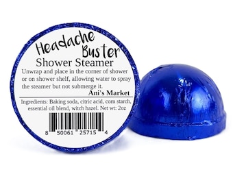 May include: Blue shower steamer with the text "Headache Buster Shower Steamer" and "Ani's Market" on the label. The label also includes the ingredients: baking soda, citric acid, corn starch, essential oil blend, and witch hazel. The steamer has a barcode and the text "Net wt: 2oz".
