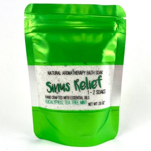 May include: A green resealable pouch containing a white bath soak labeled "Sinus Relief". The label also states "Natural Aromatherapy Bath Soak", "Hand Crafted with Essential Oils", "Eucalyptus, Tea Tree, Mint", "1-2 Soaks", and "Net Wt: 26 oz".