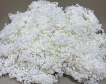 May include: A close-up of a pile of white, fluffy, synthetic fiberfill. The fiberfill is commonly used for stuffing pillows, cushions, and other soft items.