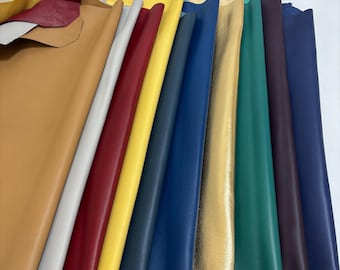 May include: A collection of colorful leather hides in various shades, including tan, white, red, yellow, blue, green, and gold. The leather pieces are arranged in a fan-like display, showcasing their different textures and colors. The image highlights the variety of leather available.