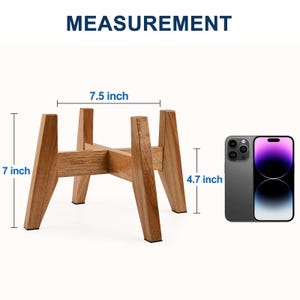 May include: A light brown wooden plant stand with a cross-shaped base and four angled legs. The stand features the text "RambleLand" on one side. Dimensions are clearly labelled as 7 inches in total height, 7.5 inches wide, and 4.7 inches tall.
