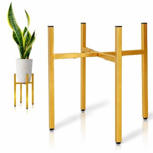 May include: A gold metal plant stand with a square top and four legs. The stand is designed to hold a potted plant. A smaller gold plant stand with a white pot and a snake plant is also visible.