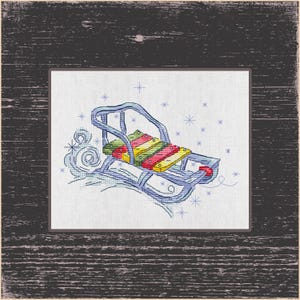 May include: Embroidered image of a vintage sled with a colorful seat. The sled is blue with a seat made of wooden slats in red, yellow, and green. Snowflakes and swirling snow are also embroidered.