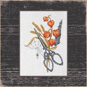 Könnte beinhalten: Kreuzstichmuster mit einer silbernen Schere, Weizenähren, orangefarbenen Lampionblumen und einer dunklen Feder. Eine Spinne und ein Netz sind ebenfalls im Design enthalten. Das Kunstwerk ist vor einem weißen Hintergrund angeordnet.