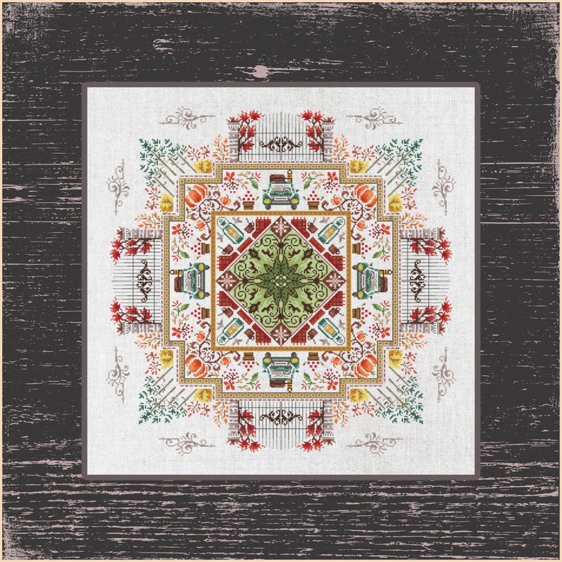 May include: A framed cross-stitch design featuring a symmetrical pattern with autumn elements. The design includes pumpkins, gates, bottles, and a central starburst motif. The color palette is dominated by orange, green, red, and brown hues.
