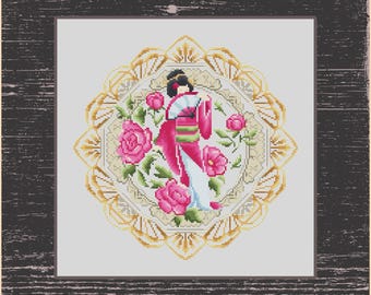 May include: A cross-stitch pattern featuring a woman in a pink and white kimono standing in a circle of pink roses and green leaves. The circle is surrounded by a gold and white decorative frame.