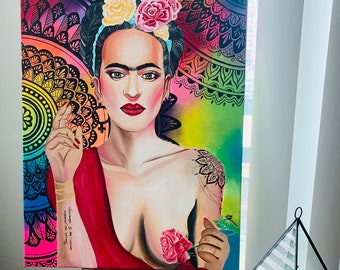 Puede incluir: Una pintura colorida de Frida Kahlo con una flor en el pelo y una rosa en la mano. El fondo es un arcoíris vibrante con diseños de mandala. La pintura incluye el texto "Piensa en mí cuando pintes."