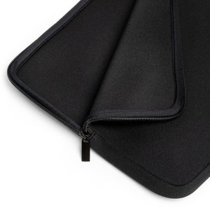 以下が含まれることがあります： 黒いジッパー付きのラップトップスリーブで、柔らかくパッド入りの内装になっています。スリーブは開いており、ジッパーのプルタブが見えています。