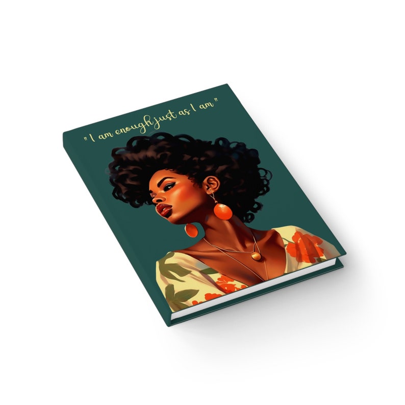 May include: A teal green journal with a floral design and a portrait of a woman with dark brown hair and orange earrings. The text "I am enough just as I am" is printed on the front cover.