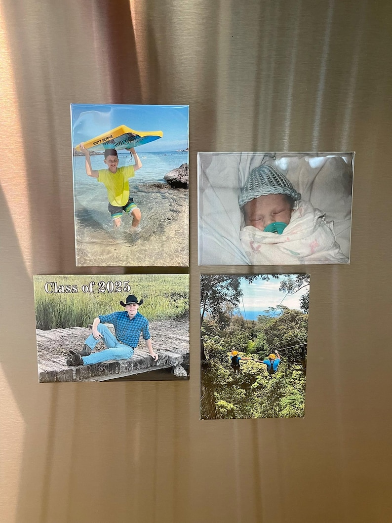 Puede incluir: Cuatro imanes rectangulares con fotograf&iacute;as. Uno muestra a una persona sosteniendo una tabla de surf en la playa. Otro muestra a un beb&eacute; envuelto en una manta. Un tercer im&aacute;n tiene el texto "Class of 2025". El &uacute;ltimo im&aacute;n muestra a personas haciendo tirolesa.
