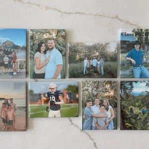 Puede incluir: Una colecci&oacute;n de ocho impresiones fotogr&aacute;ficas rectangulares con varios retratos familiares y vistas panor&aacute;micas. Una impresi&oacute;n muestra el texto "Class of 2020". Las im&aacute;genes est&aacute;n montadas sobre una superficie de color claro.