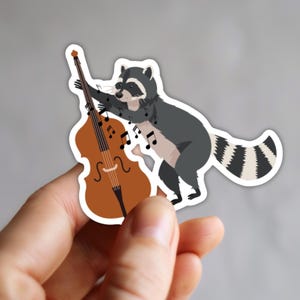 Adesivo - Músico de violoncelo - Personagem guaxinim fofo - Adesivo de vinil