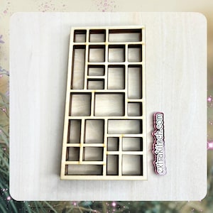 May include: A wooden organizer with a grid of rectangular compartments of varying sizes. The organizer is made of light brown wood and has a natural finish.