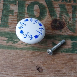 May include: White ceramic knob with a blue floral design. The knob comes with a silver screw.