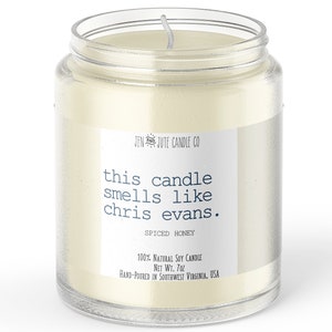 May include: A clear glass jar candle with a white label that reads "JEN JUTE CANDLE CO this candle smells like chris evans. SPICED HONEY 100% NATURAL SOY CANDLE NET WT. 7oz HAND-POURED IN SOUTHWEST VIRGINIA. USA"
