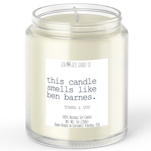 May include: A clear glass jar candle with a white label. The label reads "this candle smells like ben barnes." The candle is a 100% natural soy candle, net wt. 7oz (200g). The candle is hand-poured in Southwest Virginia, USA.