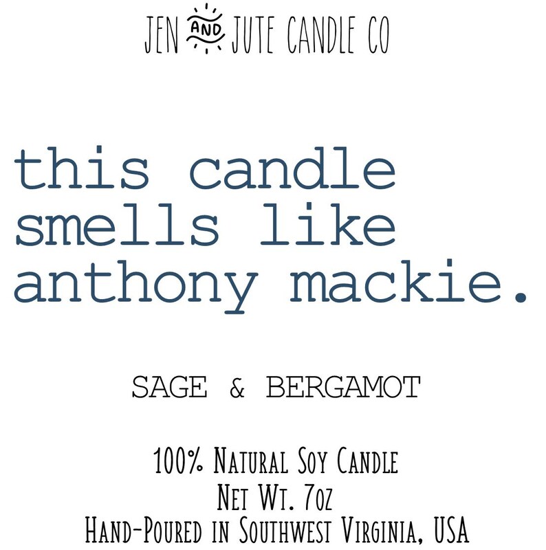 May include: A candle with the text "this candle smells like anthony mackie." The candle is labelled "SAGE & BERGAMOT" and is described as a "100% NATURAL SOY CANDLE" with a net weight of 7 oz. The candle is hand-poured in Southwest Virginia, USA.