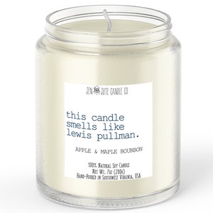 May include: A clear glass jar candle with a white soy wax candle inside. The label reads "JEN & JUTE CANDLE CO" and "this candle smells like lewis pullman."  The scent is "APPLE & MAPLE BOURBON". The candle is 100% natural soy and weighs 7 ounces.