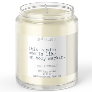 May include: A clear glass jar candle with a white label that reads "JEN & JUTE CANDLE CO" and "this candle smells like anthony mackie." The label also says "SAGE & BERGAMOT", "100% NATURAL SOY CANDLE", "NET WT. 7oz", and "HAND-POURED IN SOUTHWEST VIRGINIA, USA".