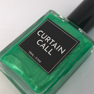 May include: A small bottle of green nail polish with a black label that reads "CURTAIN CALL" and "15mL - 0.5oz".