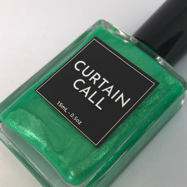 May include: A small bottle of green nail polish with a black label that reads "CURTAIN CALL" and "15mL - 0.5oz".