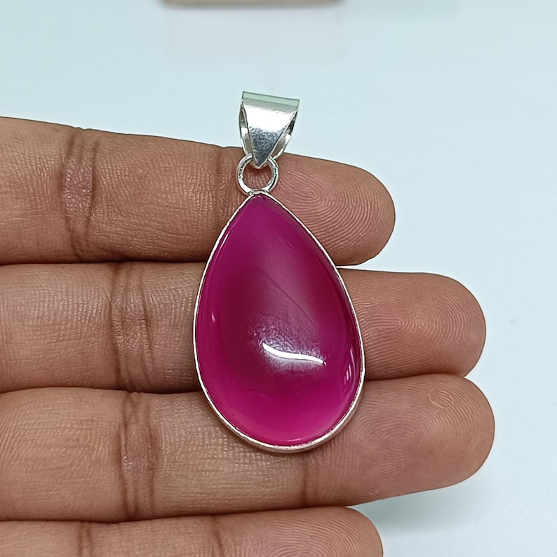May include: A teardrop-shaped pendant with a pink agate gemstone set in sterling silver.