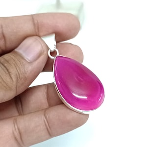 May include: A teardrop-shaped pendant featuring a bright pink agate gemstone set in a silver frame.