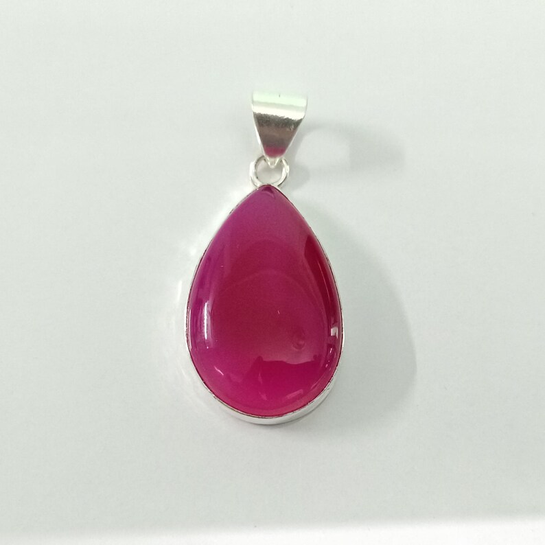May include: A silver pendant featuring a teardrop-shaped pink agate gemstone.