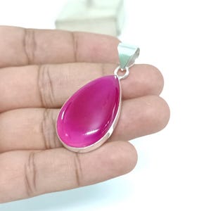 May include: A teardrop-shaped pendant with a pink agate gemstone set in sterling silver.